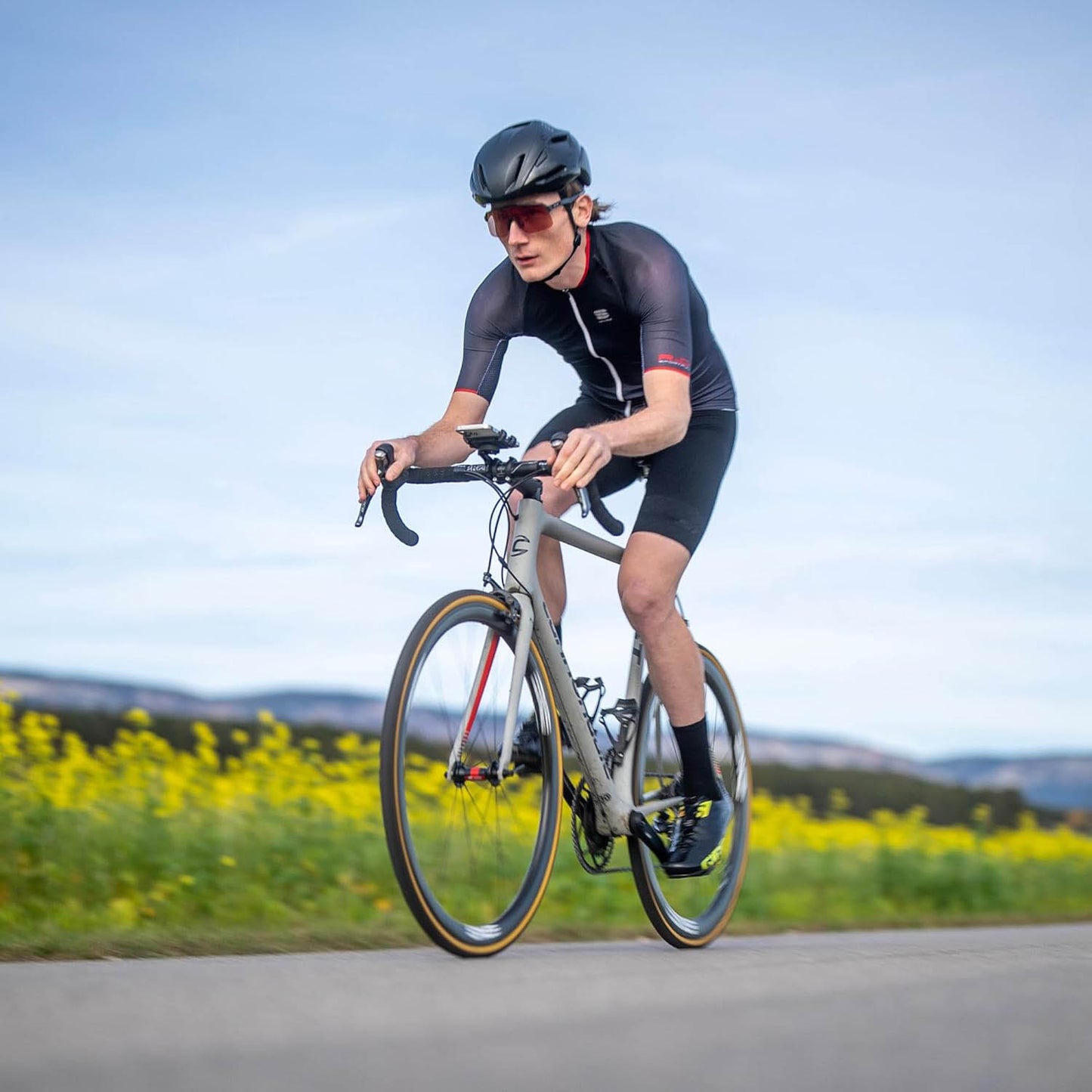 Road biker riding bike with SP Connect Roadbike Bundle Universal Clamp SPC+ holding his phone