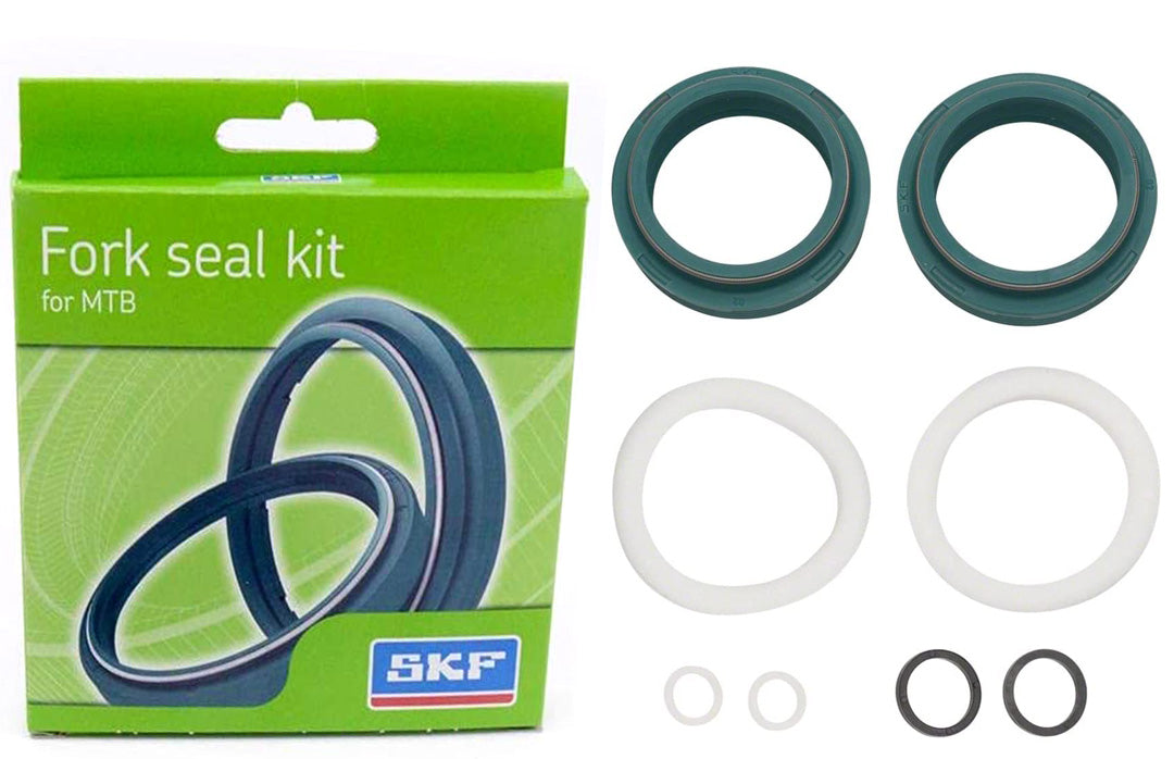 Studio image of box and seals for bicycle fork. Two large green seals, 2 white large seals, 2 small white seals and 2 medium black seals.