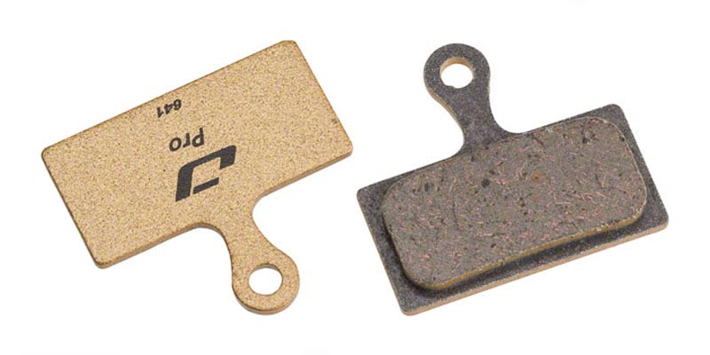 Jagwire Pro Semi-Metallic Disc Brake Pads For Shimano, showing both the back and front of the brake bad, with the back being a bronze gold color.