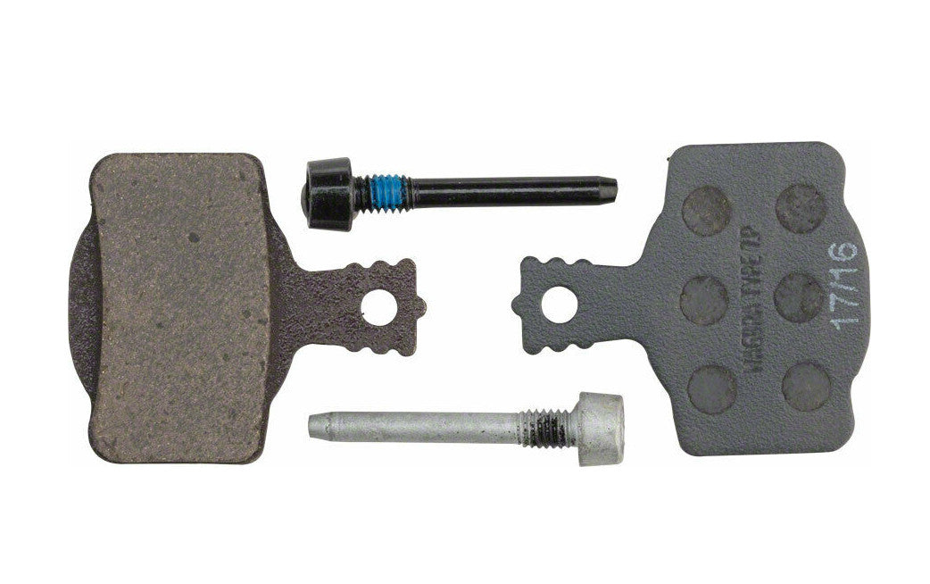 Studio image of Magura 7P Performance Disc Brake pads. Left pad has the brake surface showing, the right pad has the back side of the brake showing. There is a black bolt in the top middle of the image and a silver bolt in the bottom middle of the image.