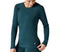 Studio image of woman wearing a Smartwool emerald green long sleeve crew neck baselayer. There is a white Smartwool logo on the bottom left of the top near the hip