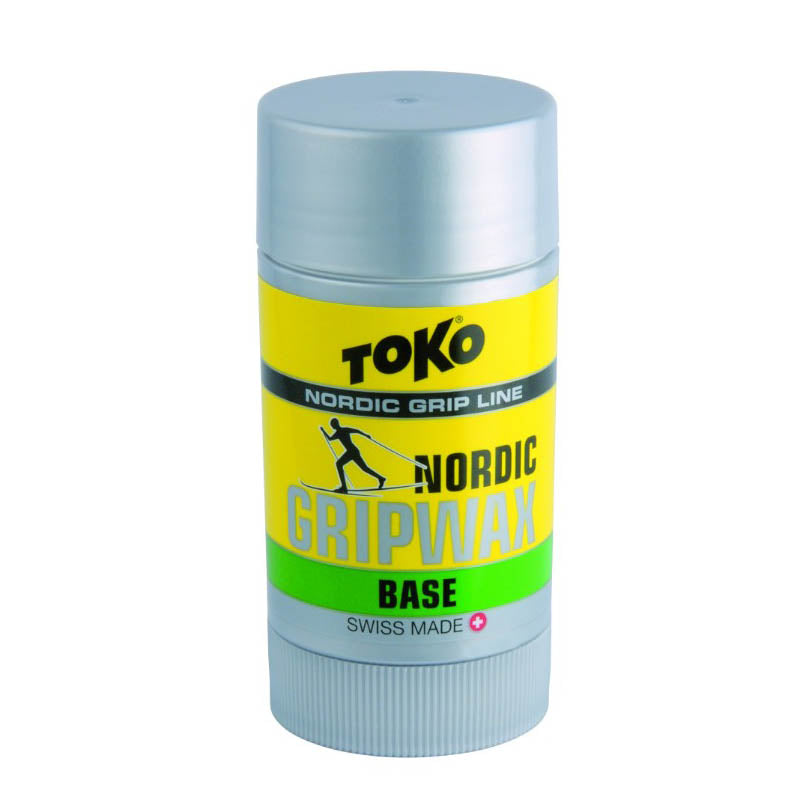 A stick of Toko Nordic Grip Wax Base in green color, with product details and branding visible.