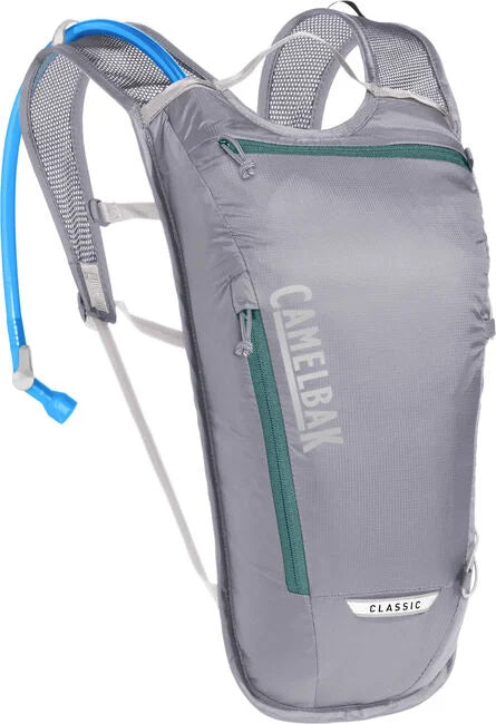 studio view of silver Camelbak Classic hydration pack with teal zippers and blue hose
