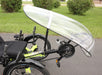 Lifestyle image of a HP Velotechnik Stream Fairing installed on a lime green HP Velotechnike recumbent trike . The trike is on a paved driveway with grass and three bushes in the background