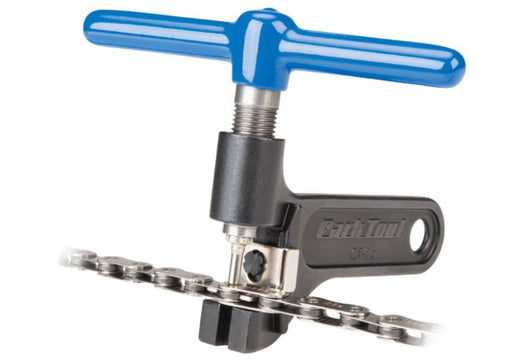 Studio view of black and blue Park Tool Pro Chain tool pushing a pin out of a bicycle chain