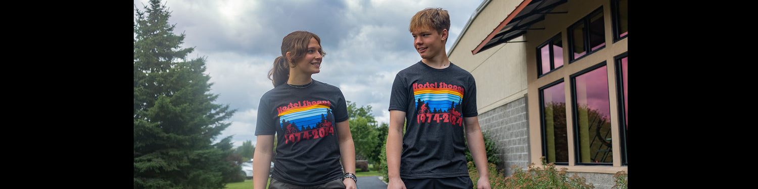 Hostel Shoppe staff model our new black vintage t-shirts with colorful retro design on a cloudy day.