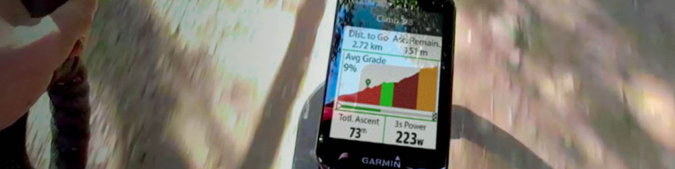 Image of a Garmin GPS bike computer attached to a bike stem, which the shadow of the road and a bike underneath.