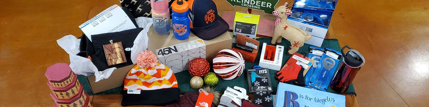 An assortment of bike accessories and gift ideas sit on a table decorated for the Christmas holiday.