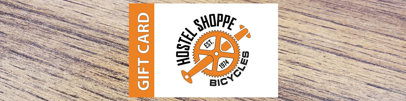 Image of Hostel Shoppe e-gift card against a wooden background.