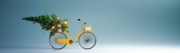A yellow bike carrying a Christmas tree and a gift are against a blue background.