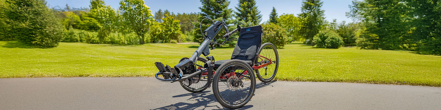 An HP Velotechnik Gekko Handcycle in red on a bike path.