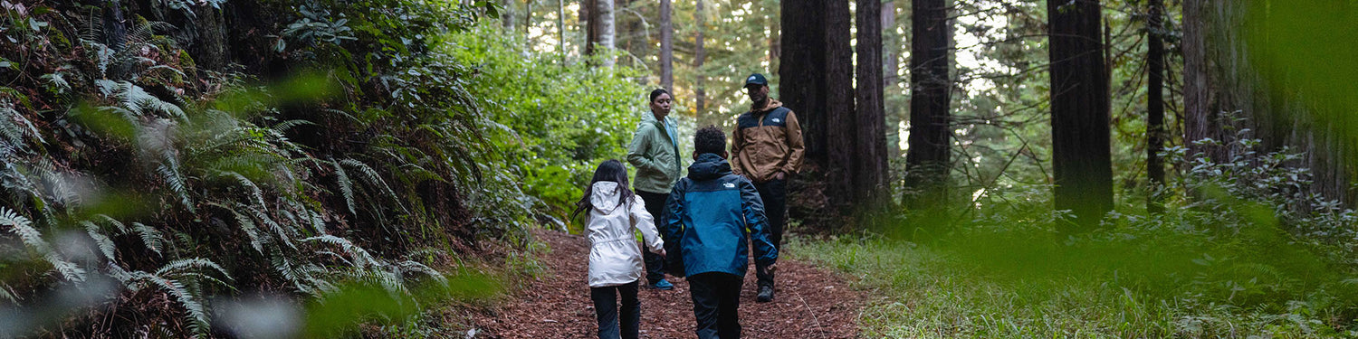 Hikers trek thourgh the woods wearing jackets from The North Face.