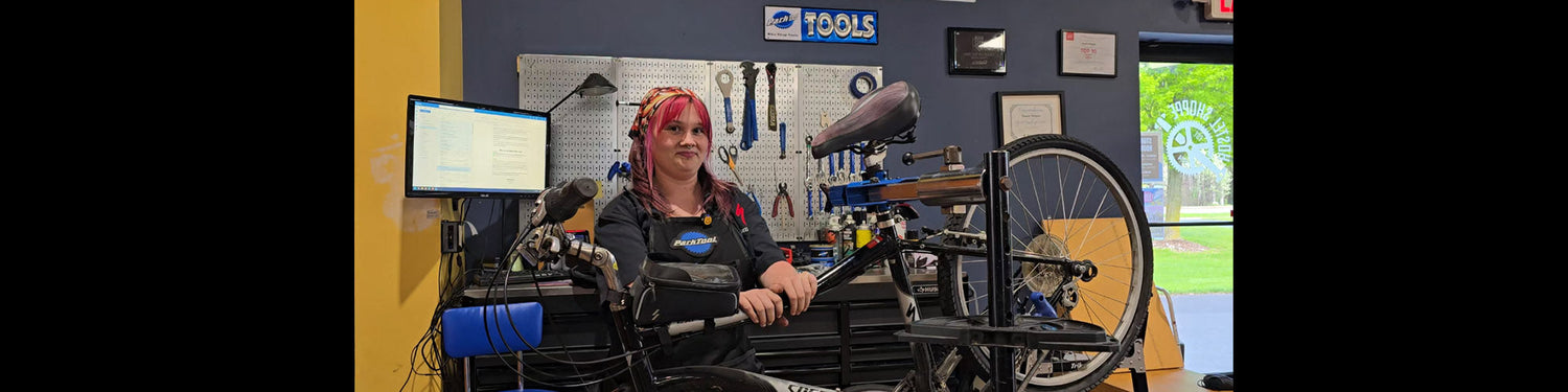 Hostel Shoppe mechanic, Ava, prepares to fix a flat tire on a bicycle.
