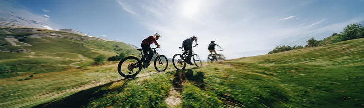 Three mountain bikers ride a trail on Specialized Bikes.