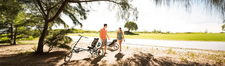 Ac ouple stops to take a break from riding their Sun Seeker trikes along a road side in a countryside setting.