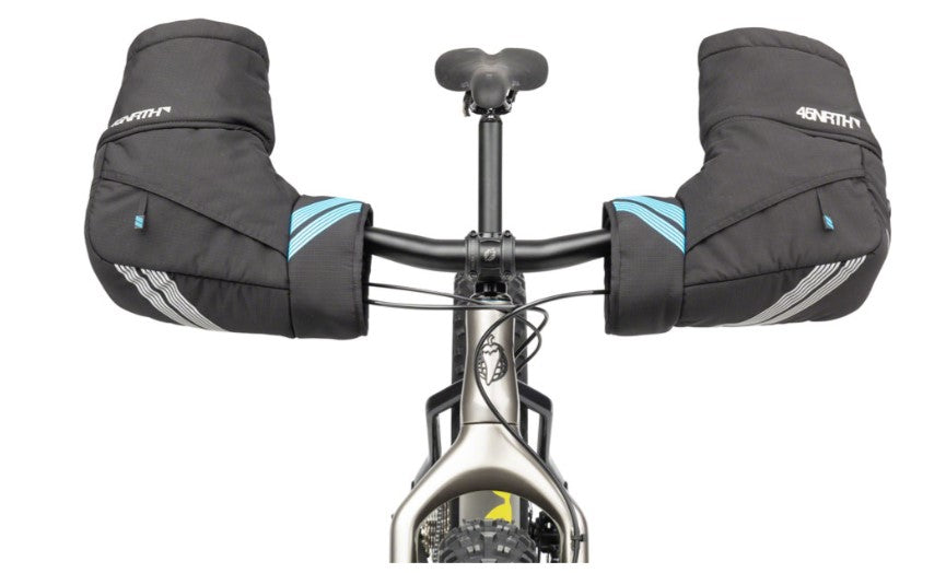 Bicycle handlebar with black 45NRTH Cobrafist pogies installed on a white background