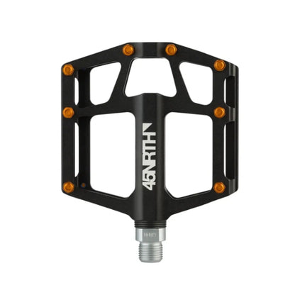 Top view of the 45NRTH Heiruspecs 9/16 Inch Aluminum Black Platform Pedal with orange studs against a white background.