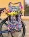 Po Campo Orchard Grocery Pannier meadow mounted on bike carrying flowers, outdoor photo.