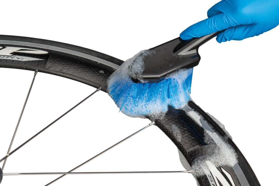 Studio image of soft bristled brush cleaning rim of bicycle