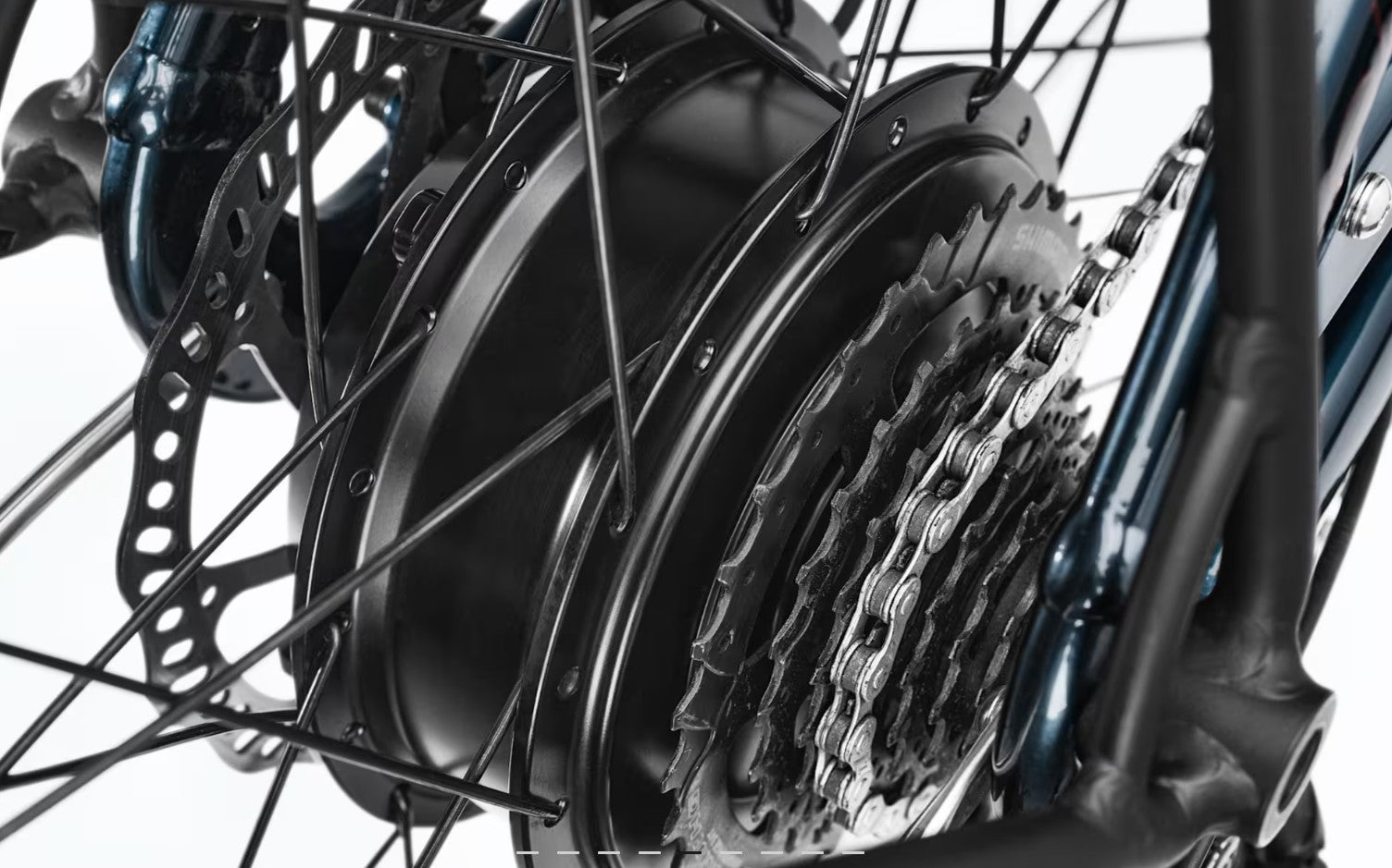 Close-up of a bicycle wheel with a hub drive motor, chain, and gear system on a white background