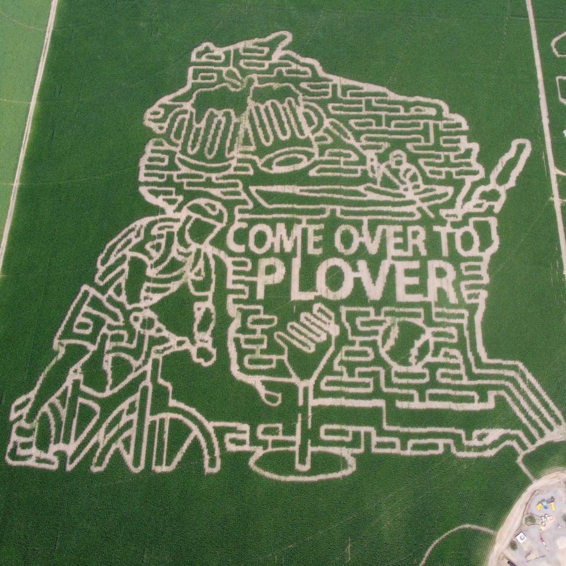 An aerial shot of the Feltz Dairy Farm corn maze is modeled after the shape of Wisconsin with the inclusion of a biker, potato masher, baseball, kayak, beer, and the words "come to plover."