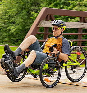 A man rides his electric assist trike down a bike path.