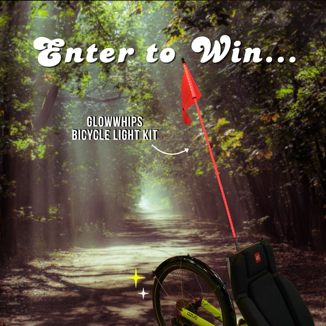 A bicycle light kit with a red flag and glowwhip is shown in a forest path scene with text reading 'Enter to Win.'