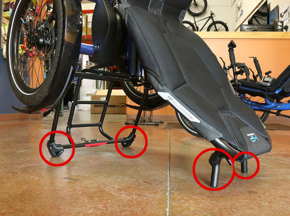 Close up side view of the HP Velotechnik stand-up feet kit installed onto the back of the seat and back of the rack of a HP Velotechnik Delta trike, with kit parts circled in red. 