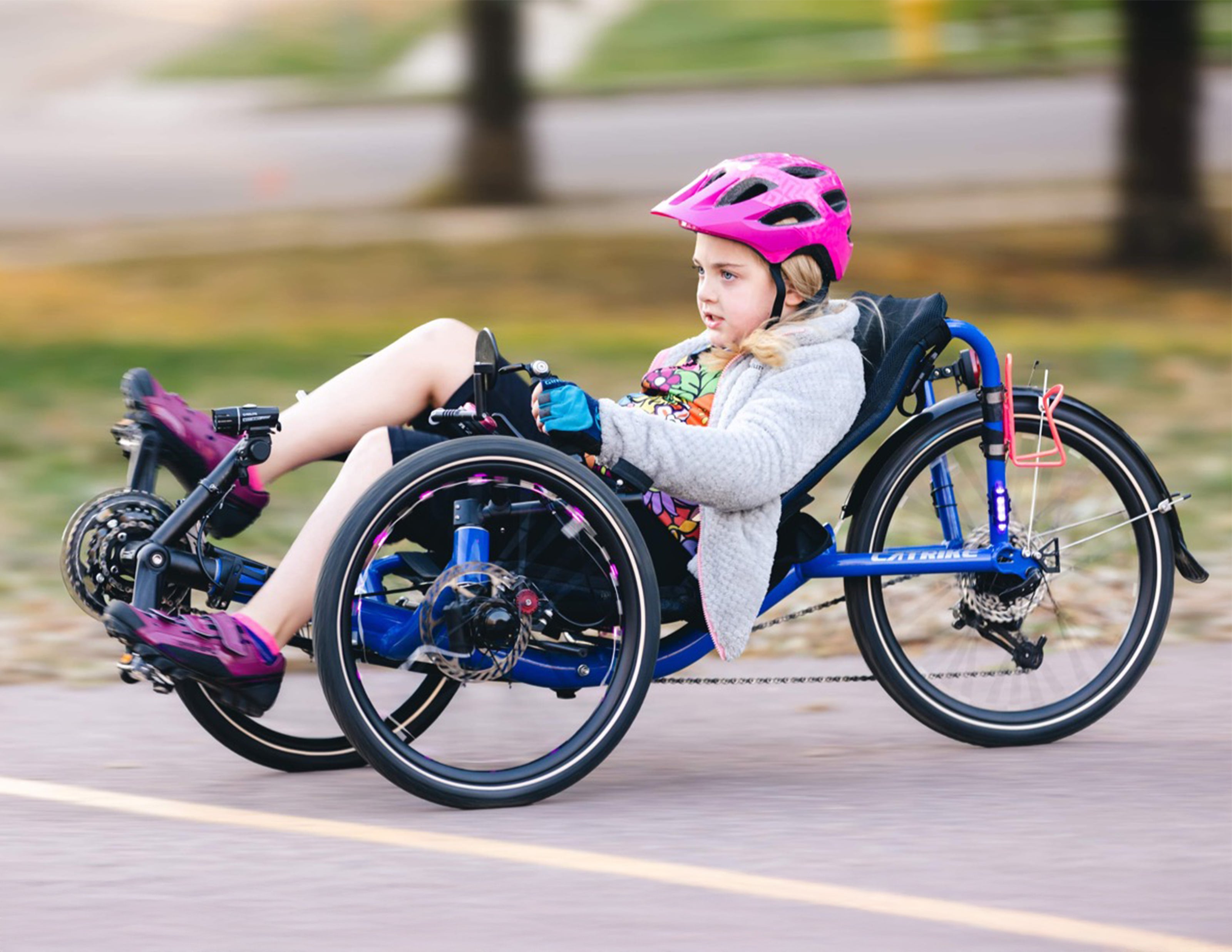 A young girl rides her Catrike Pocket recumbent trike.