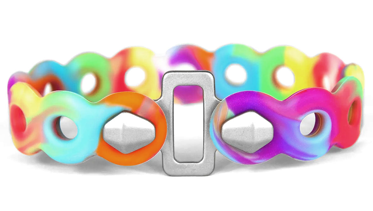 Studio close up image of a tie dye rubber strap with holes across the full length and a silver metal clasp securing both ends of the strap into a closed loop. 