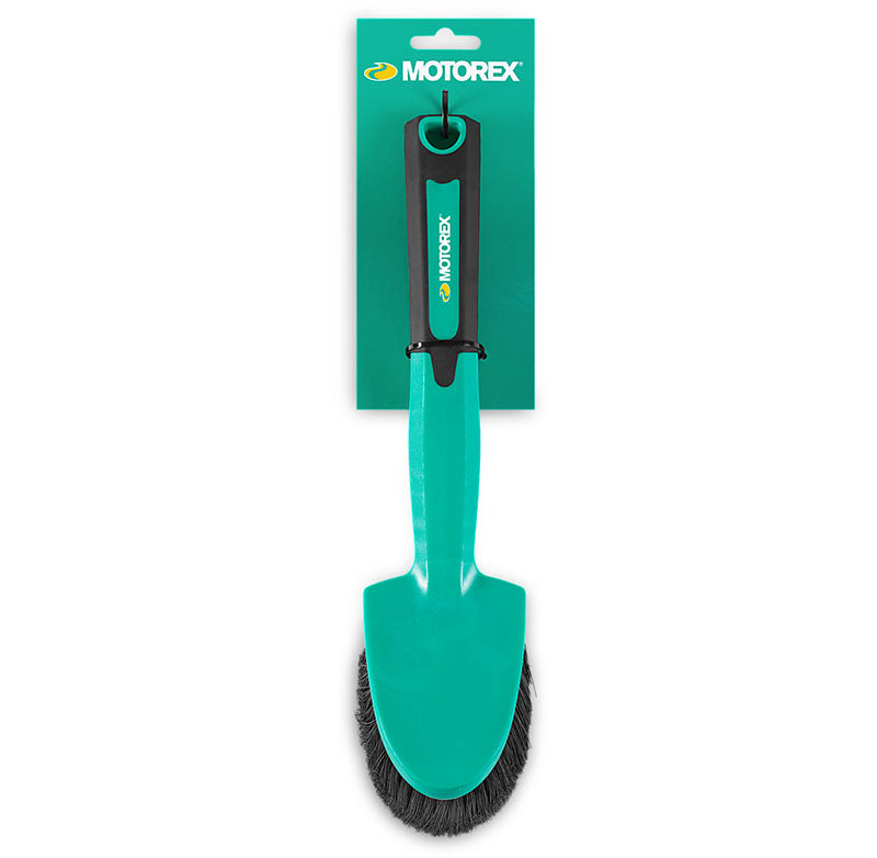 Studio image of green handled, black bristled brush on green Motorex hangtag.