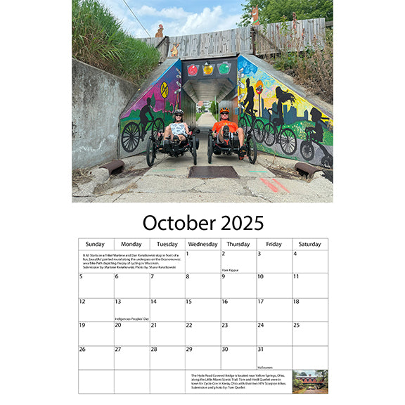 October 2025 features two trikers in front of a cycling mural in Wisconsin.