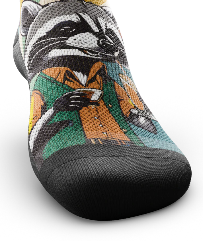 Top toe area of a multicolored  sock with racoon wearing brown button down shirt and green vest drinking cups of coffee. 