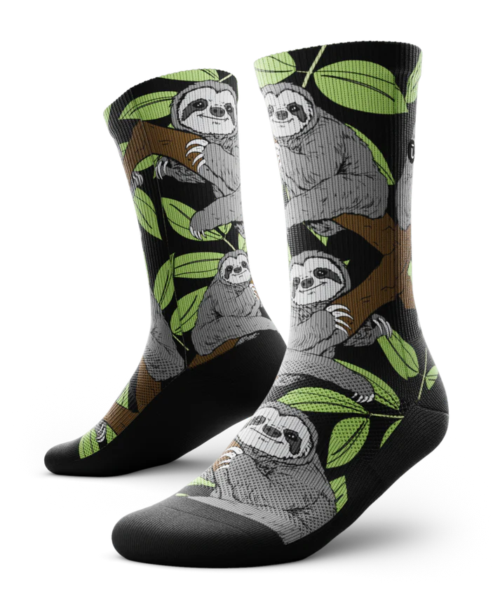 Pair of socks with grey sloths in trees with black background and soles
