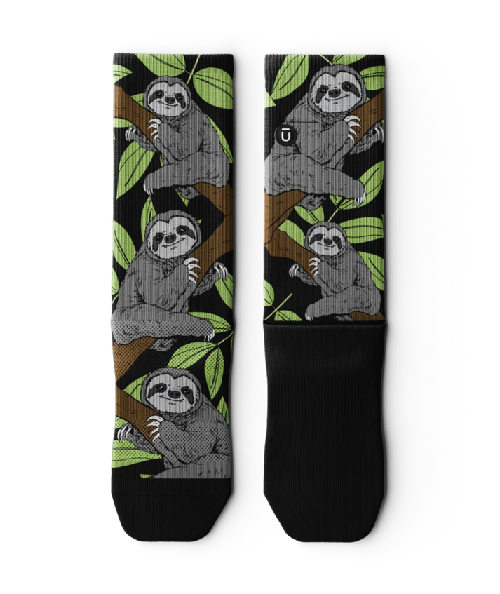Pair of socks laying flat with grey sloths in trees with black background and soles