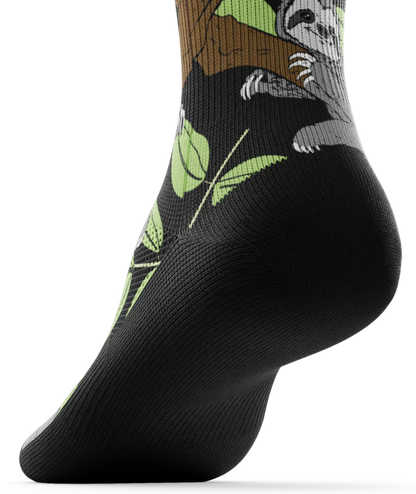 Bottom black sole view of sock with sloths in trees on main part of sock