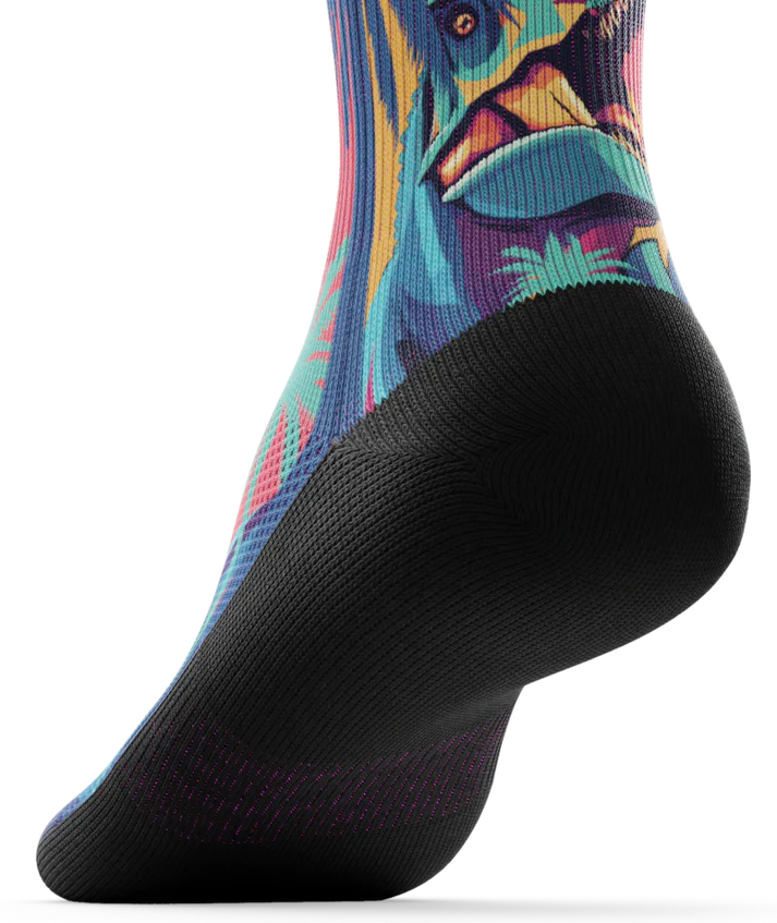 Bottom sole of multicolored  sock with T-rex dinosaurs and palm trees on main part of sock