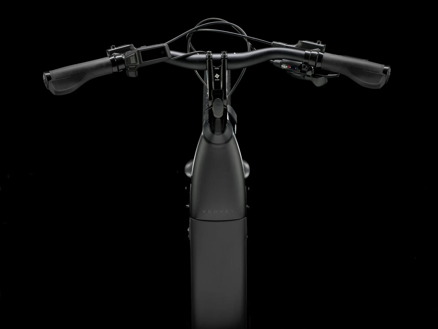 Top cockpit view of the Trek Verve+ 3 Lowstep Gen 3 e-Bike in Black, shown on a black background. It includes fenders, lights, rear rack, suspension seatpost, and kickstand.
