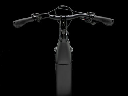 Top cockpit view of the Trek Verve+ 3 Lowstep Gen 3 e-Bike in Black, shown on a black background. It includes fenders, lights, rear rack, suspension seatpost, and kickstand.