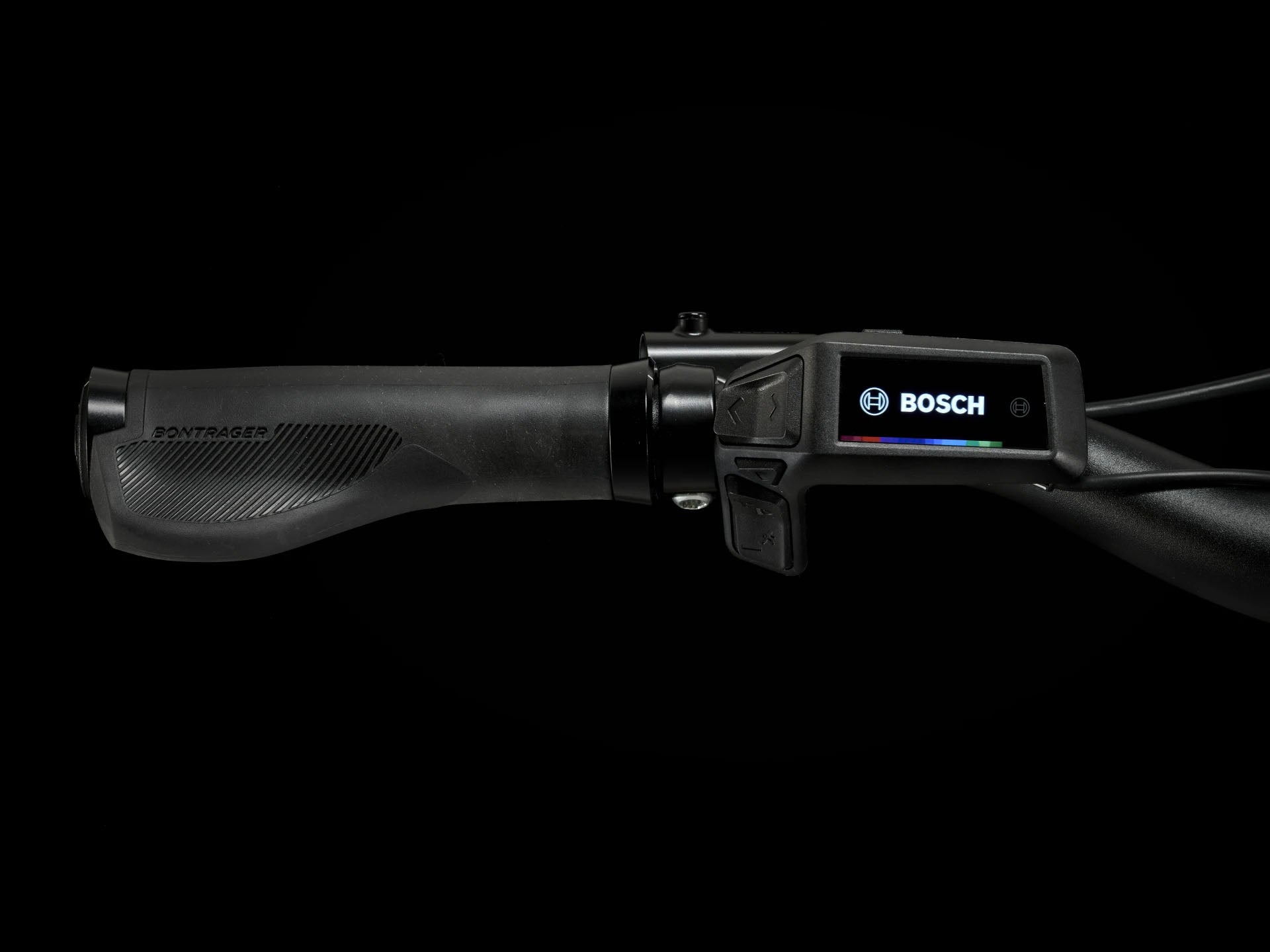 Close up view of the display/controller on the Trek Verve+ 3 Lowstep Gen 3 e-Bike in Black, shown on a black background. It includes fenders, lights, rear rack, suspension seatpost, and kickstand.