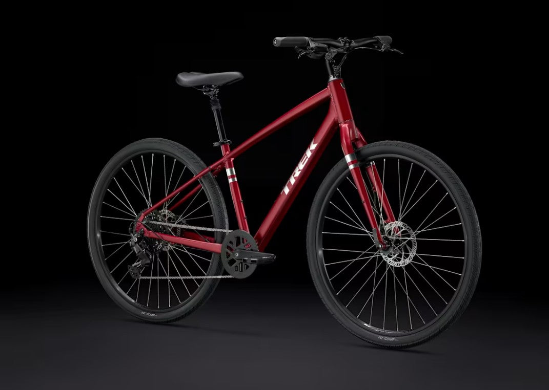Red Trek Verve bicycle with silver Trek logo on downtube on a black background.