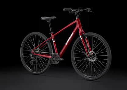 Red Trek Verve bicycle with silver Trek logo on downtube on a black background.