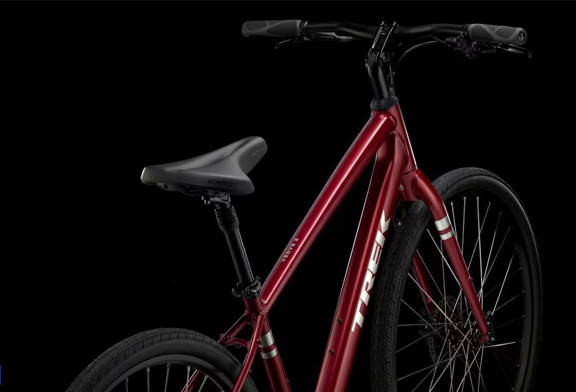 Red Trek Verve bicycle with silver Trek lettering on downtube on a black background