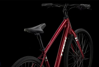 Red Trek Verve bicycle with silver Trek lettering on downtube on a black background