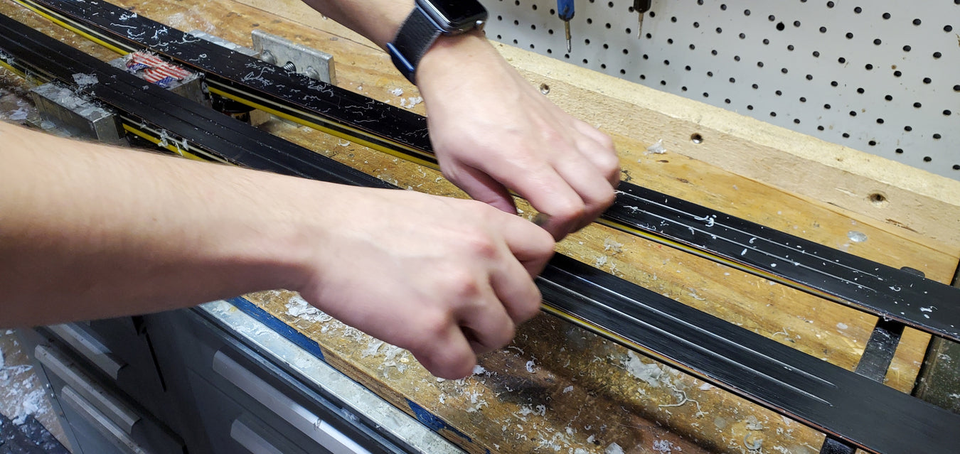 A mechanic waxes nordic skis.