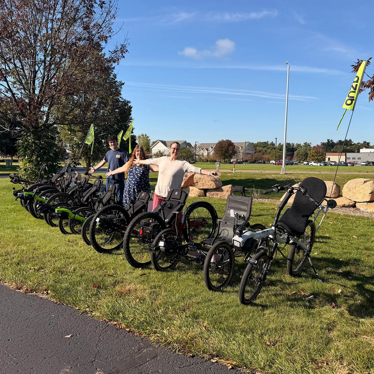 Hostel Shoppe staff line up behind a row of demo recumbent bikes and trikes from Azub and HP Velotechnik outside the Hostel Shoppe.