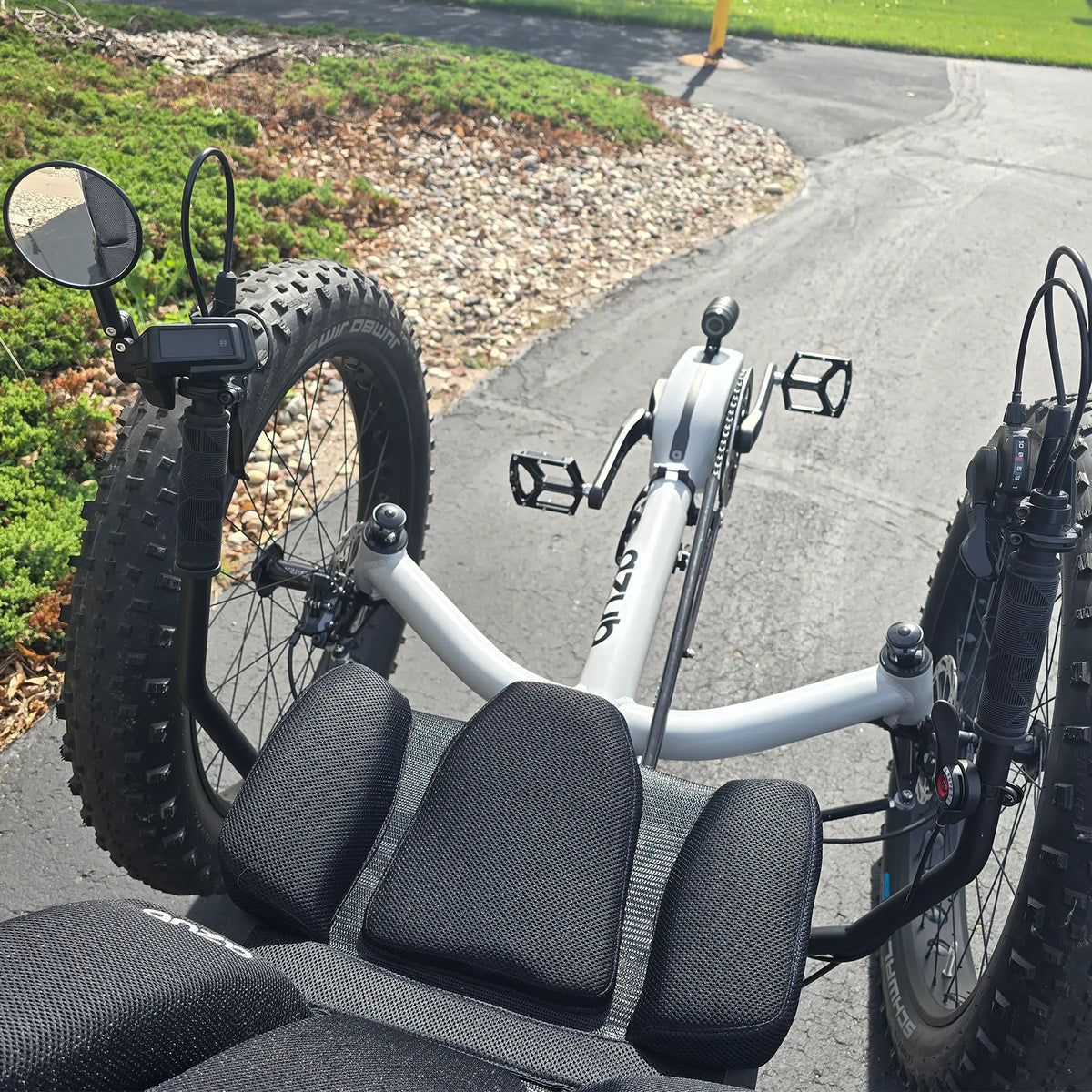 Closeup view of the mirror, handlebars and controls on the Azub Demo Fat Bosch Performance CX Dynamic Grey Recumbent Trike in an outdoor setting.