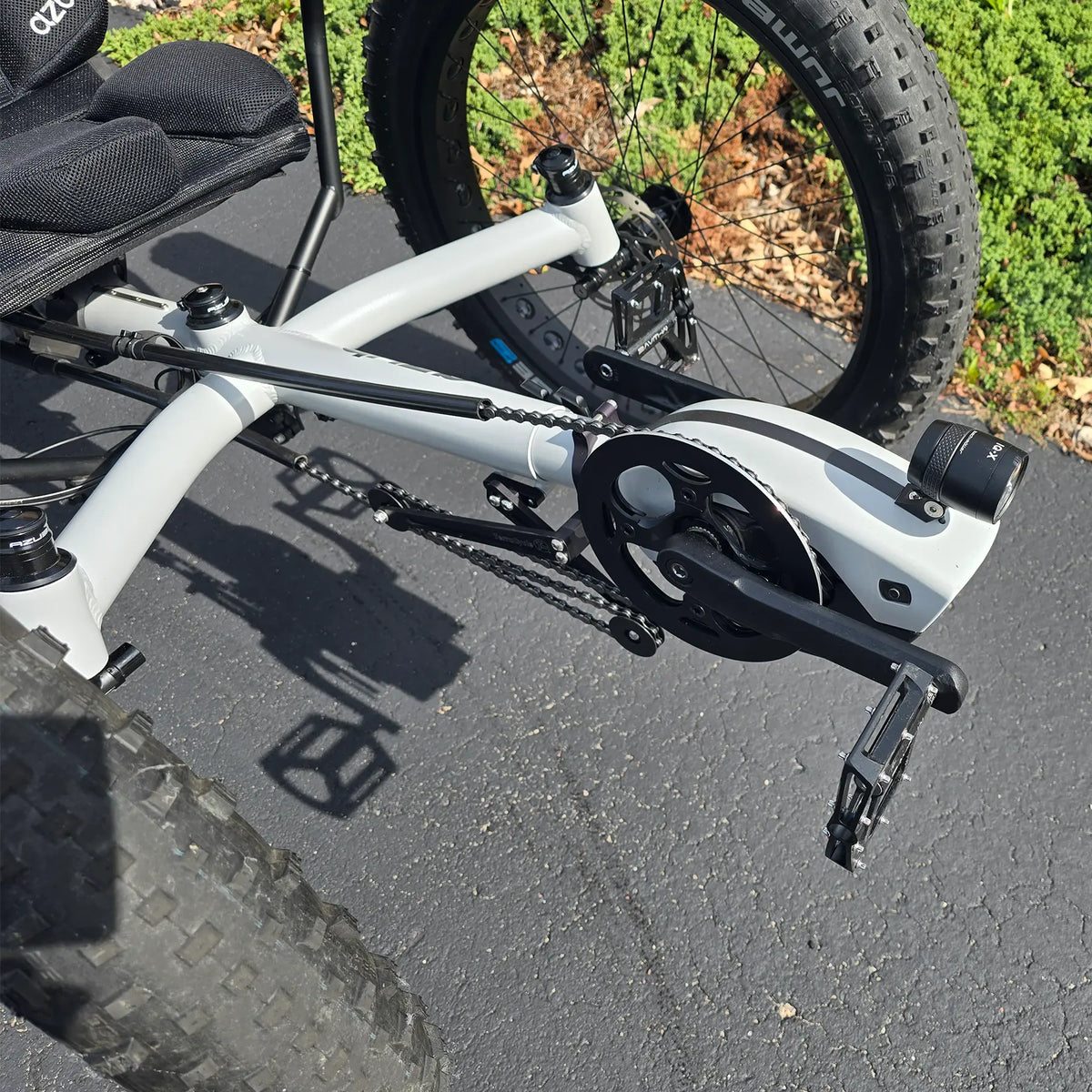 Closeup view of the motor, headlight and quick adjust on the Azub Demo Fat Bosch Performance CX Dynamic Grey Recumbent Trike in an outdoor setting.