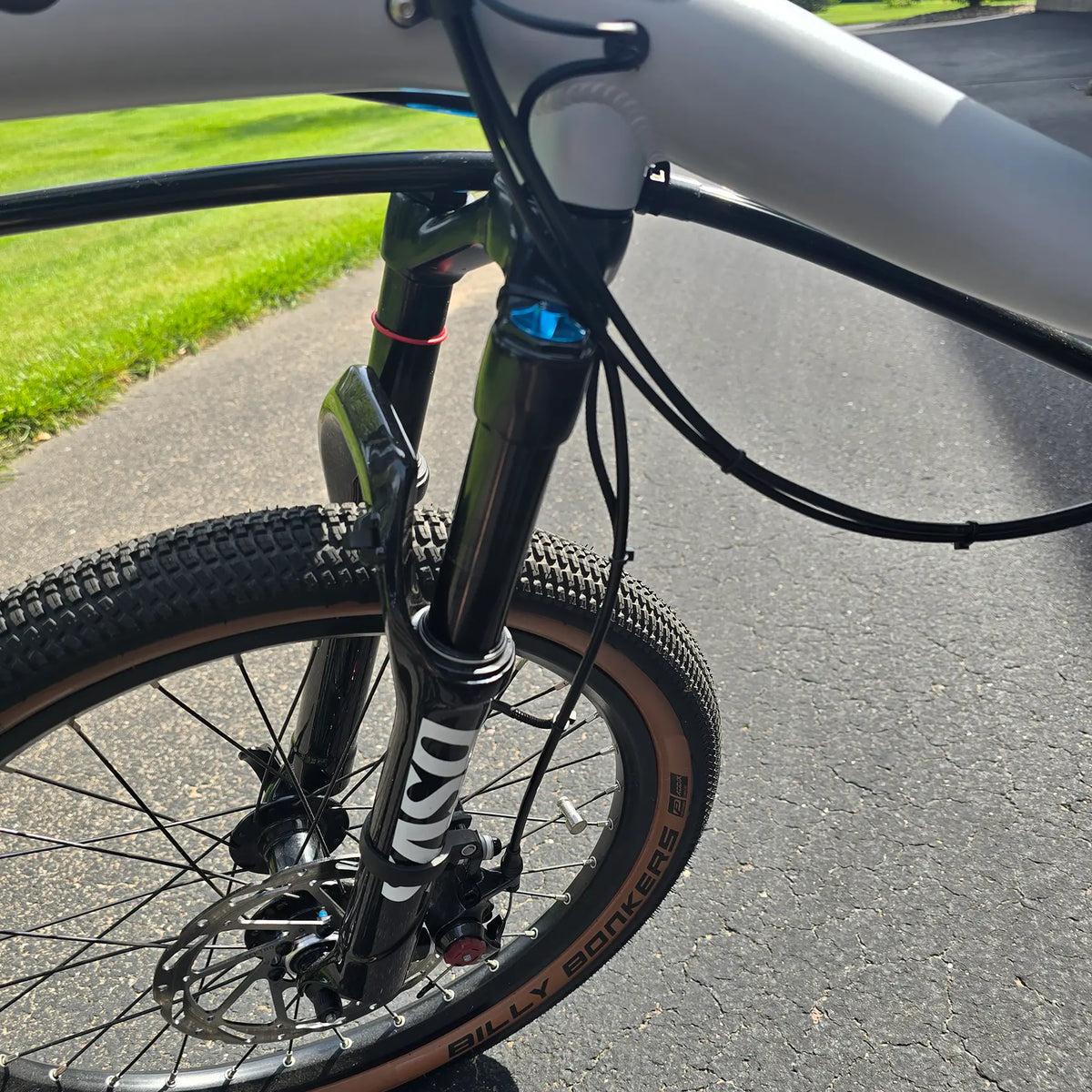 Closeup view of the suspension fork on the Azub Demo Six Bosch Performance CX Dynamic Grey Recumbent Bike in an outdoor setting.