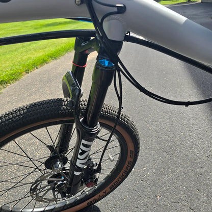 Closeup view of the suspension fork on the Azub Demo Six Bosch Performance CX Dynamic Grey Recumbent Bike in an outdoor setting.